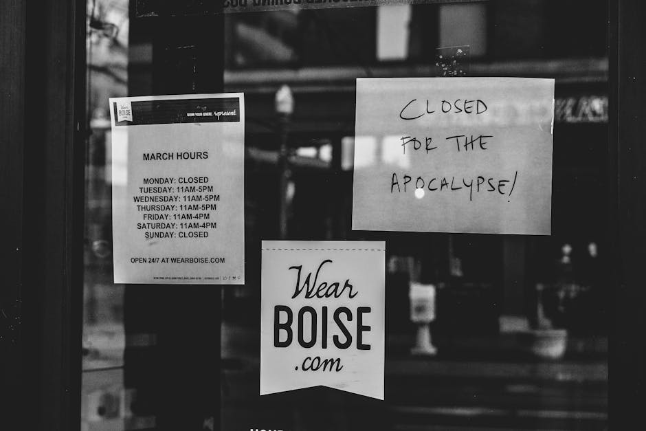 Black and white image of a closed storefront in Boise with humorous signs about closure.