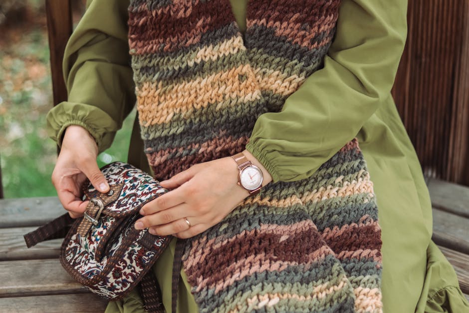 Close-up of stylish autumn fashion accessories including scarf and watch.